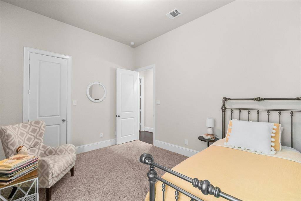 Cozy third bedroom features a soft color palette and carpeted flooring.