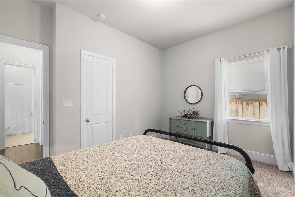 Fourth bedroom with single window and neutral decor.