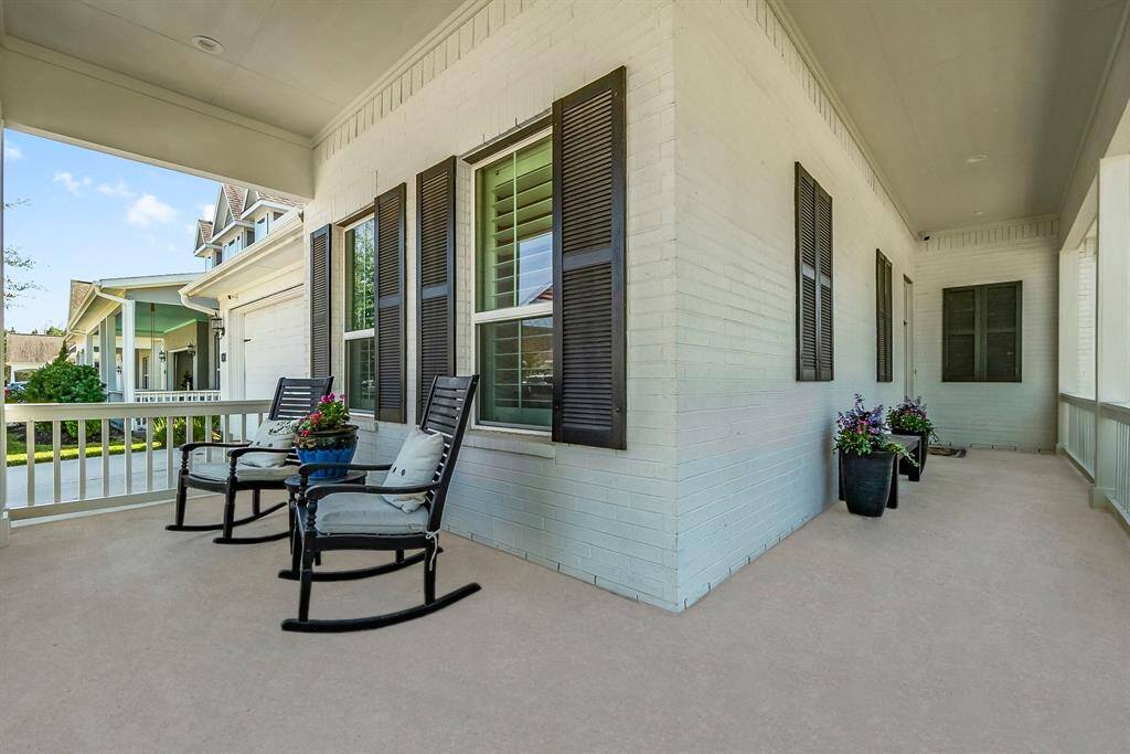 Inviting wrap-around porch with elegant black shutters creates a warm and welcoming entrance.