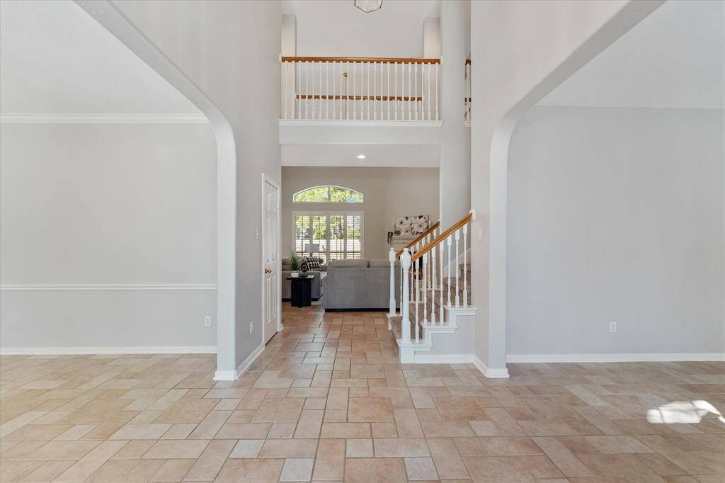 Formal entry boasts vaulted ceiling, custom tile floor, recent neutral paint and ample natural light.