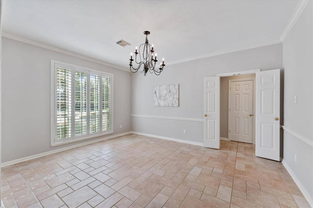 Elegant formal dining room featuring plantation shutters, chair rail, crown molding and recent paint.