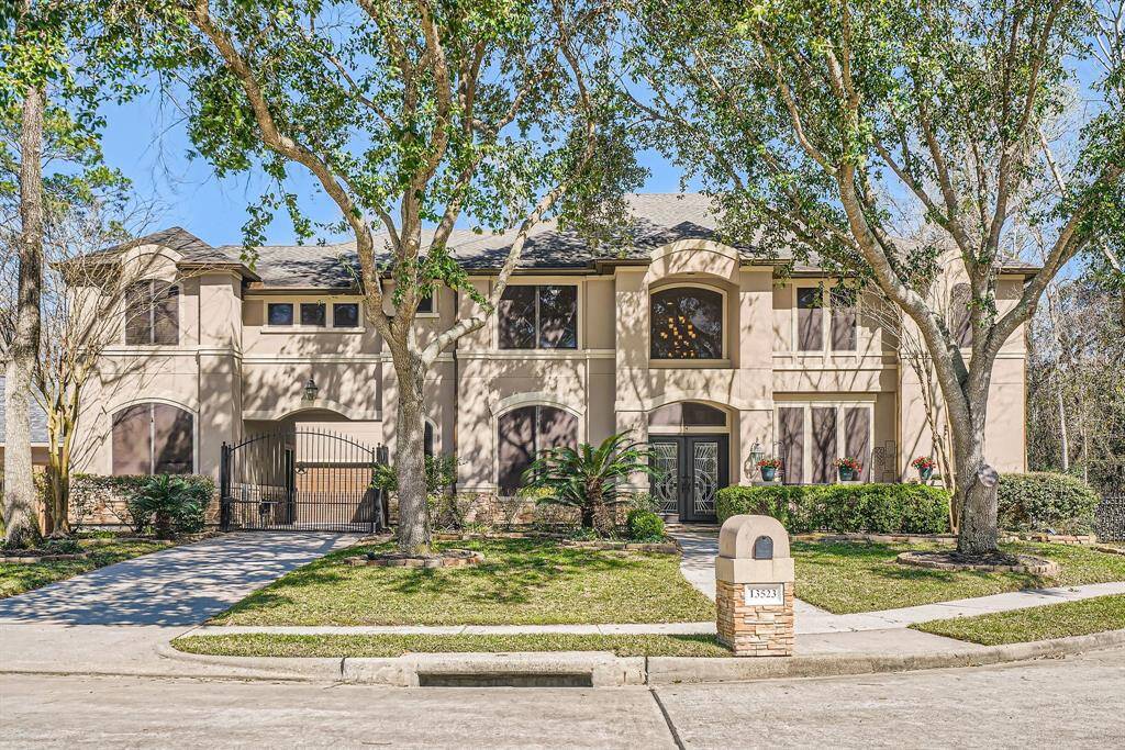 Elegant two-story home with a modern facade, surrounded by mature trees and well-maintained landscaping. Features a gated driveway and a welcoming front entrance, ideal for a family seeking style and comfort.