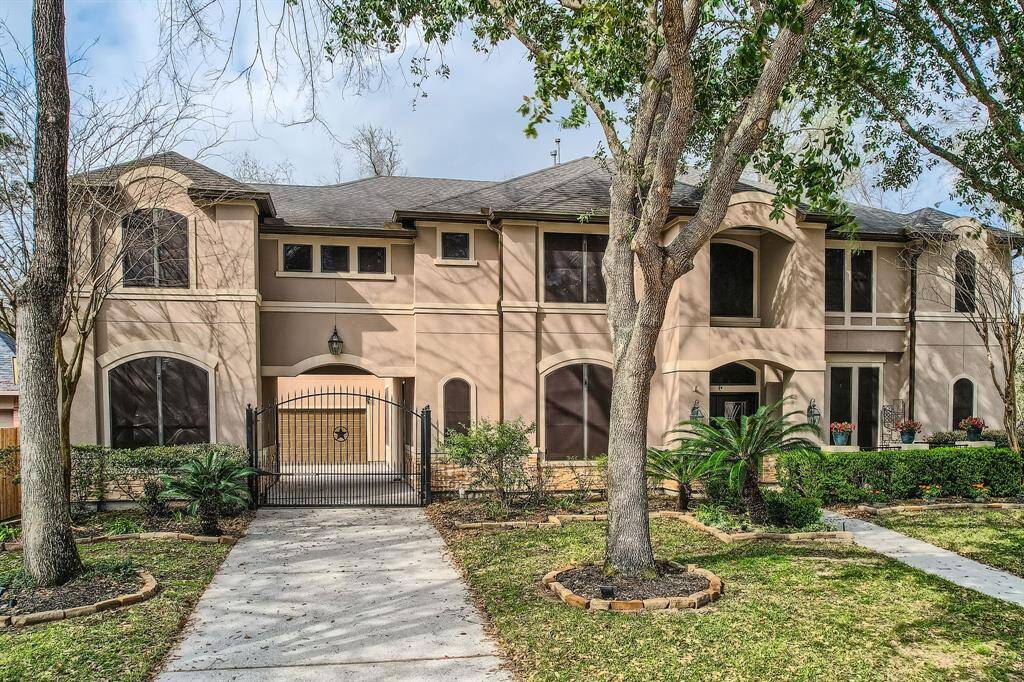 A stunning view of the home from the street with a paved driveway. The exterior showcases a combination of stucco and stone promising both comfort and sophistication within.