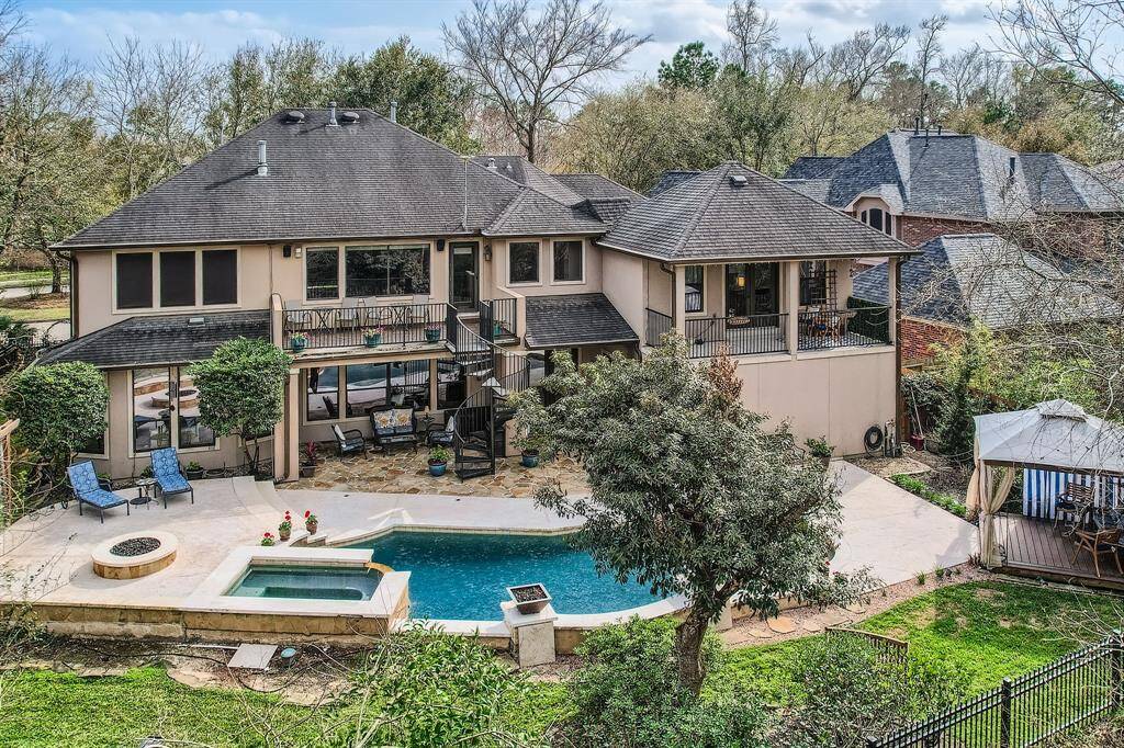 This photo if another view of the back of the home with the pool/spa, stone fire pit to the left of the pool, gazebo to the right of the pool. A back deck for your relaxation and the covered patio underneath. Another covered balcony to the right which is just outside of the 5th bedroom.