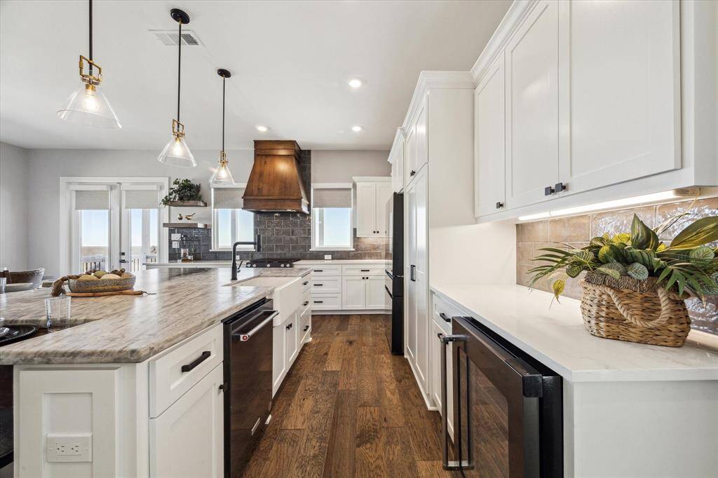 THE KITCHEN ALSO FEATURES A CORNER DRY BAR WITH WINE REFRIGERATOR.