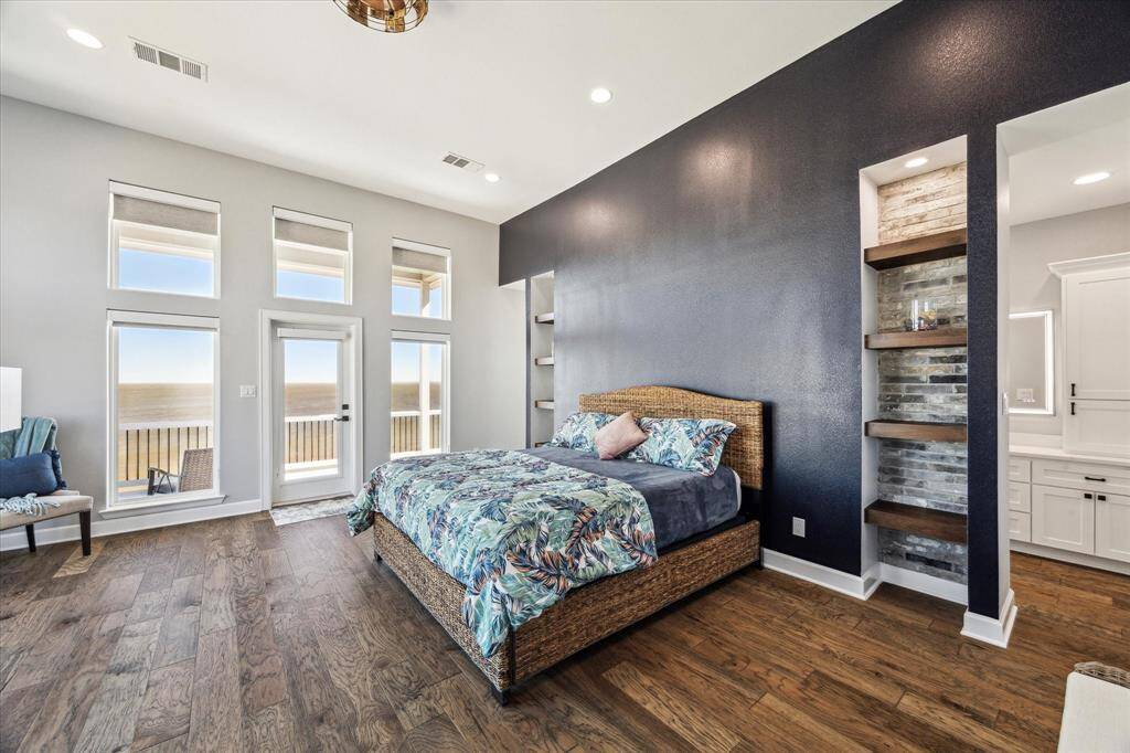 THE 2ND LEVEL PRIMARY SUITE, ALSO ACCESSED BY THE ELEVATOR, IS STUNNING WITH TRANSOM WINDOWS AND A SEATING AREA OVERLOOKING THE BAY.