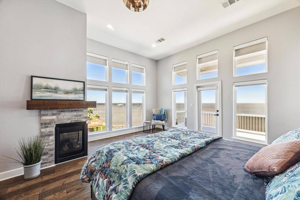 PICTURESQUE PRIMARY SUITE WITH CORNER FIREPLACE NEST TO THE SITTING AREA THAT IS SURROUNDED BY BAY VIEWS.