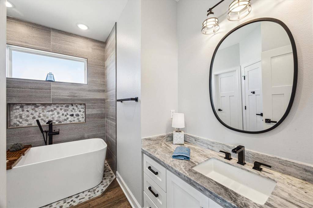 BEAUTIFULLY FINISHED SECOND PRIMARY SUITE WITH GRANITE COUNTERS AND A FREESTANDING TUB.