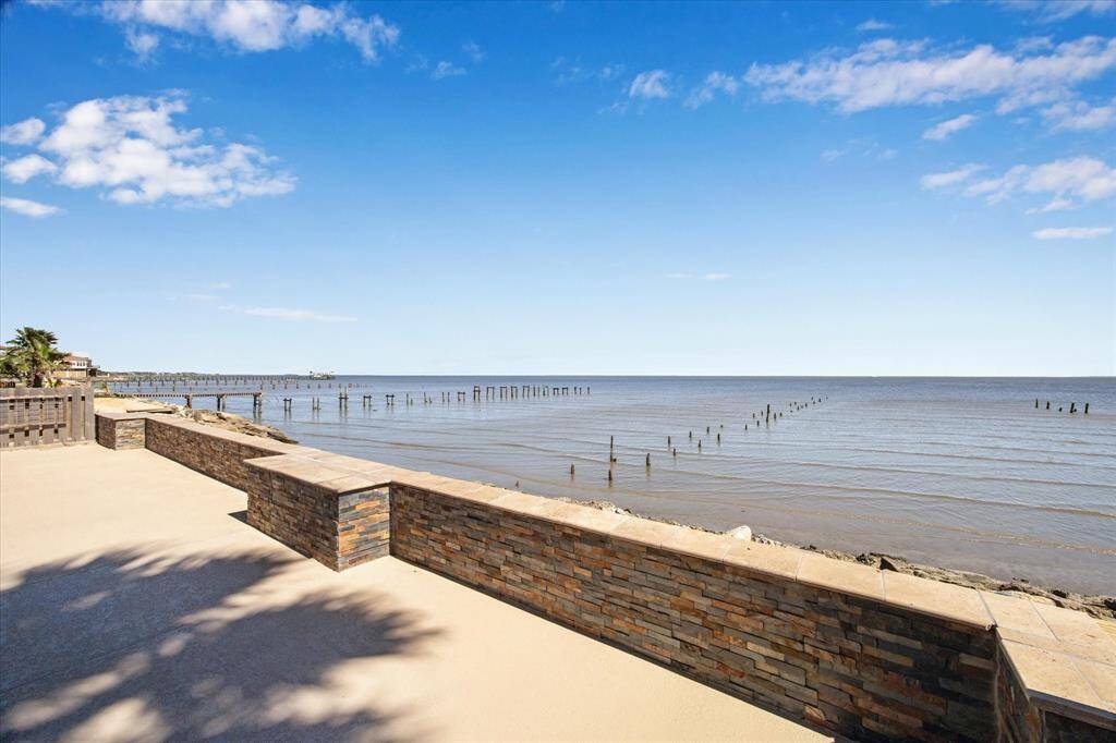 THE STACKED STONE WALL PROVIDES BOTH PRIVACY IN THE POOL AND A GREAT AREA FOR GUESTS TO SIT AND ENJOY THE BAY.