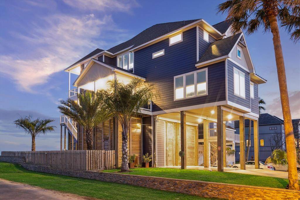 BEAUTIFUL FRONT ELEVATION AT DUSK. THE PROPERTY FEATURES COVERED PARKING FOR 2 VEHICLES, BUT THE ENTRANCE CAN ALSO ACCOMMODATE A GARAGE DOOR FOR ADDITIONAL PARKING UNDER THE HOUSE.