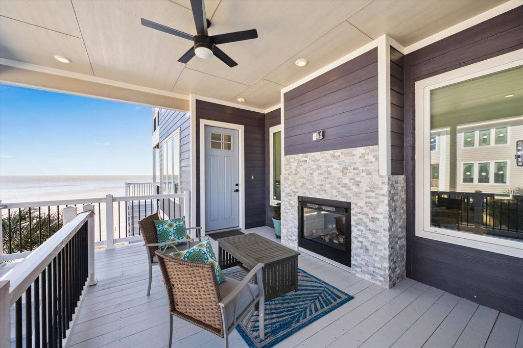 THE STAIRS LEAD YOU TO THIS PICTURESQUE FRONT PORCH WITH DOUBLE SIDED FIREPLACE OVERLOOKING THE BAY.