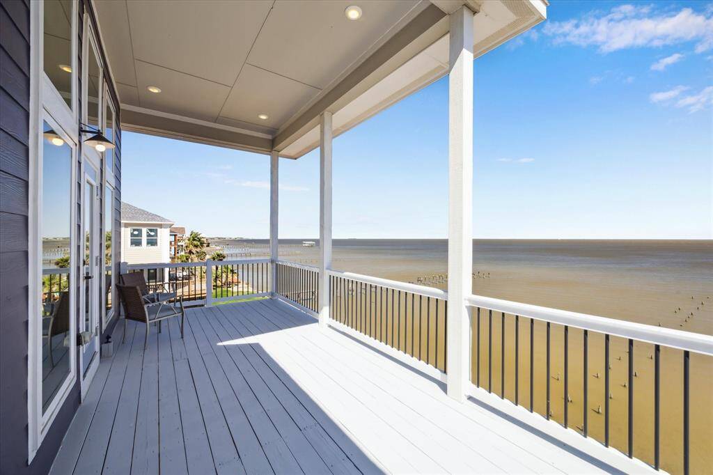OUTSIDE THE DINING ROOM AND KITCHEN IS THE SPACIOUS FIRST LEVEL BALCONY.