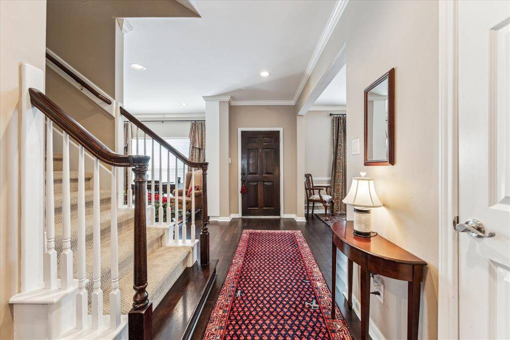Alternate view of the entry with access to a formal powder bath tucked behind the staircase.