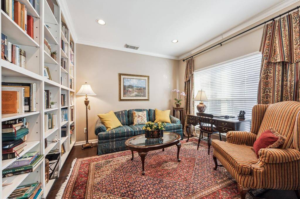 To your left, a study/sitting room beckons with a striking wall of bookshelves, perfect for showcasing books or decorative treasures.