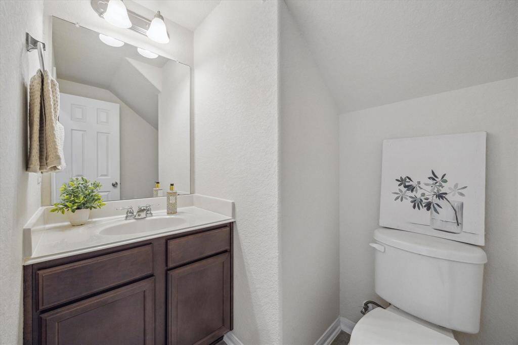 This spacious half-bath, located just off the kitchen has a built-in vanity for linen and other storage.