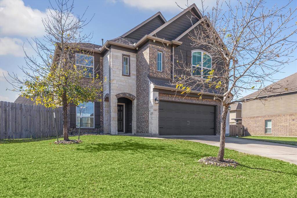 A tonal mix of light-colored stone, brick, and charcoal painted accents ensure a lovely curb appeal and shows the detail in the home's design.