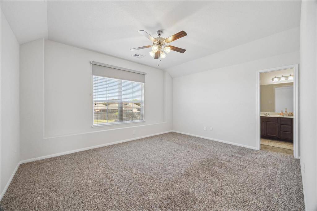 The primary suite, located upstairs, is spacious, with wall-to-wall carpeting and neutral paint.