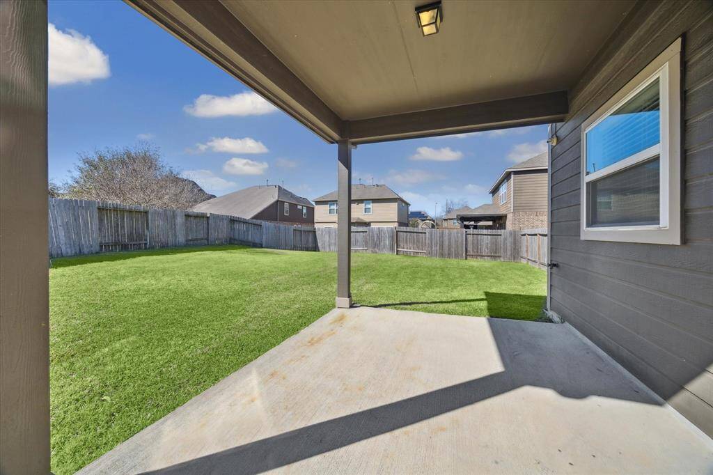 This covered patio is the perfect spot to spend shaded time outdoors in the vast backyard.