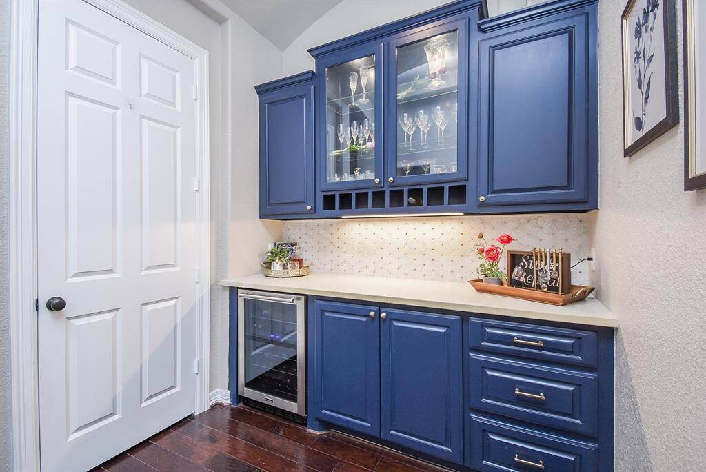 Prepare your next drink in this custom built dry bar with wine fridge.
