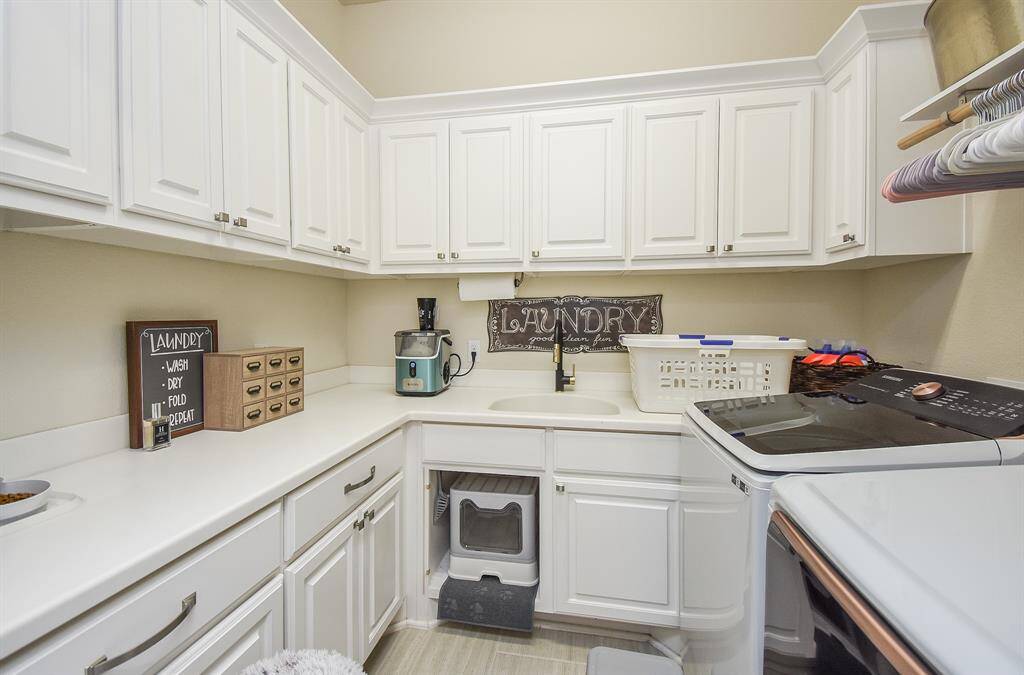 Laundry room with plenty of storage and a sink.