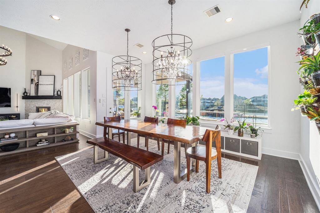 Expansive dining area bathed in natural light, featuring a living wall and custom lighting with double chandeliers for an elevated dining experience.