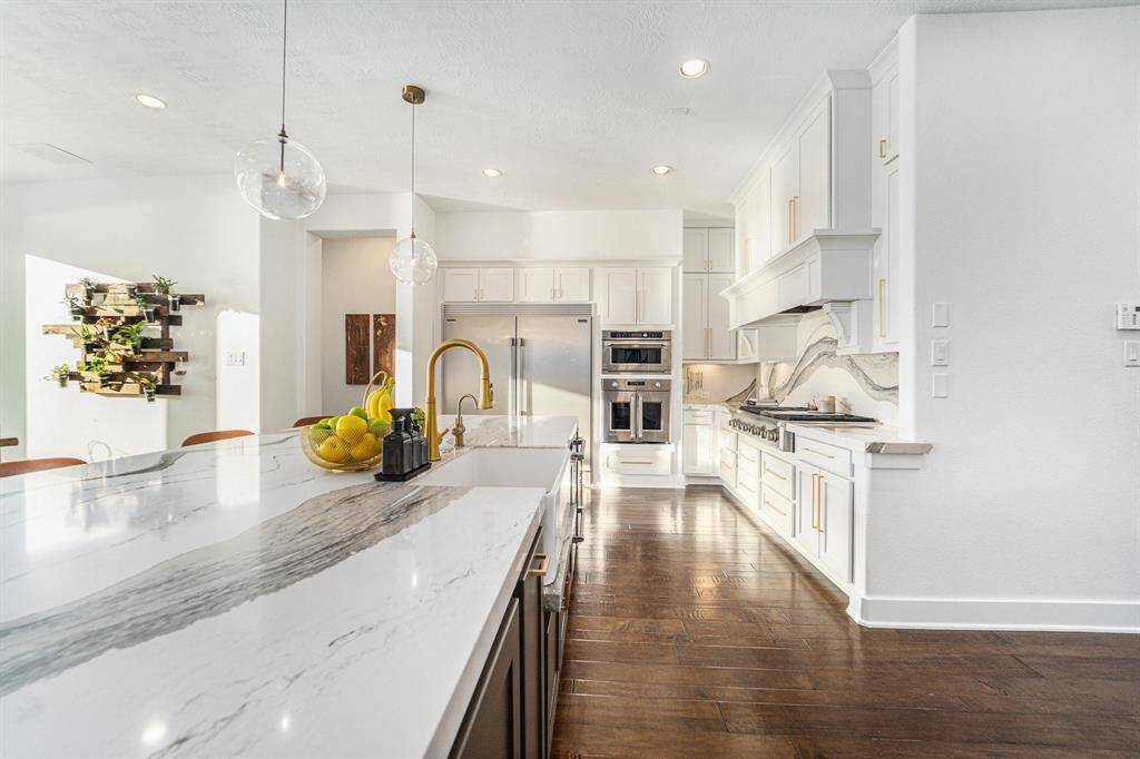 64" double wide built-in fridge, double oven, French doors, monogram appliances, 6-burner range, custom vent with spice racks built in.