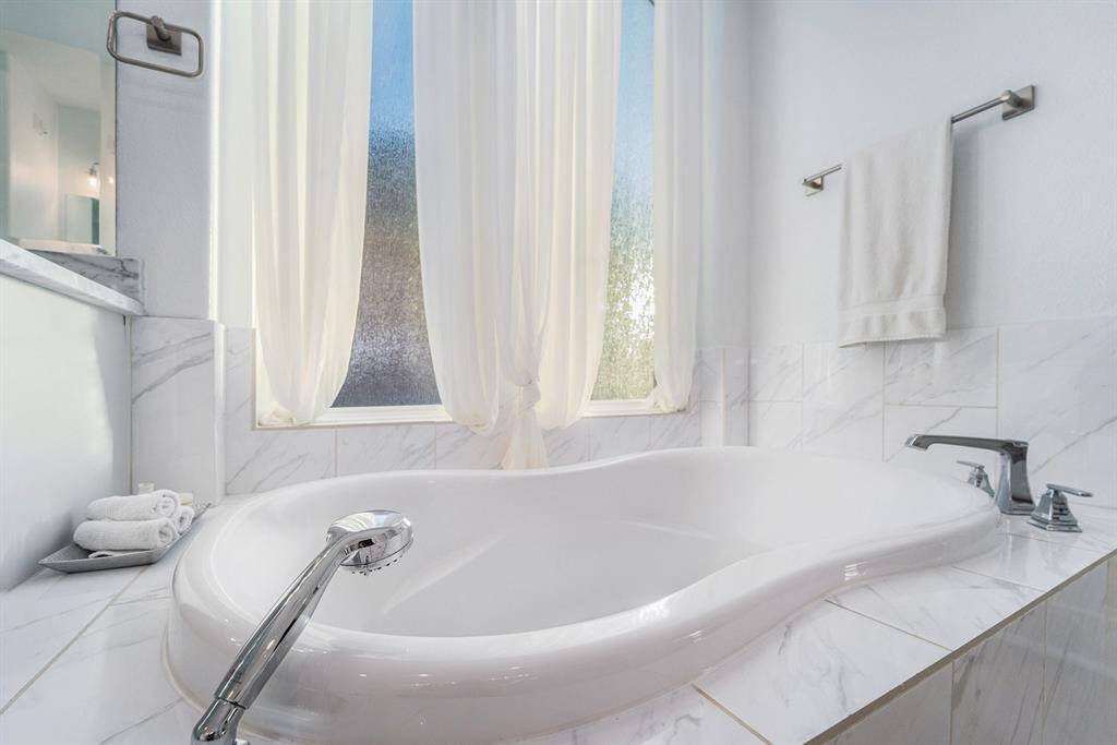 Separate soaking tub basks in natural light for a spa like retreat.