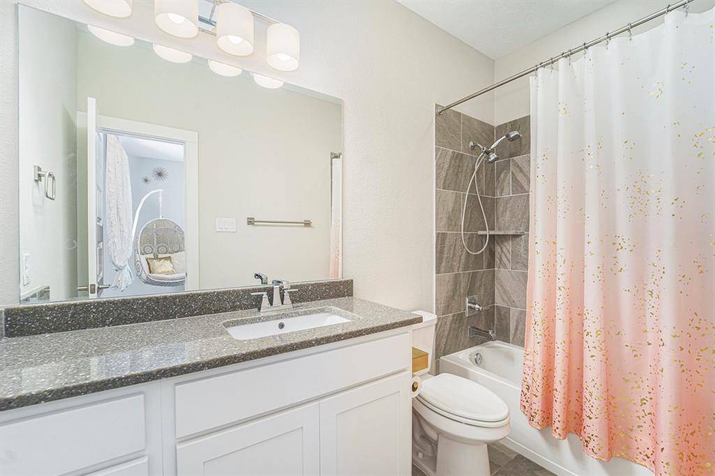 Secondary bathrooms have been updated with quartz countertops and upgraded tiles surrounding the tubs for a modern touch.
