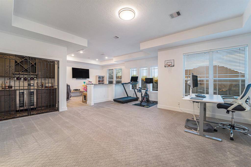 Playroom, media, flex space, dry bar - Expansive playroom with a dry bar, including a wine fridge, dual-zone temperature control, and upgraded countertops for casual dining while enjoying a movie.
