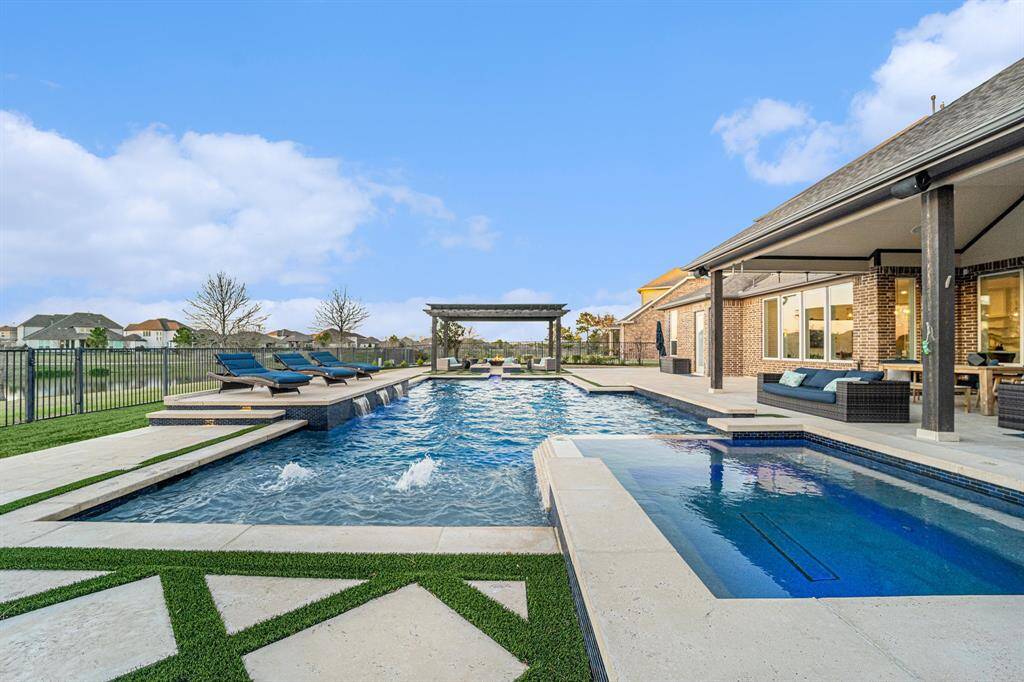 Saltwater oversized resort-style sports pool and hot tub - The backyard oasis includes a massive 14-foot hot tub with a waterfall, an oversized pool with a sun deck, a basketball goal, and a fire pit under a grand cabana.