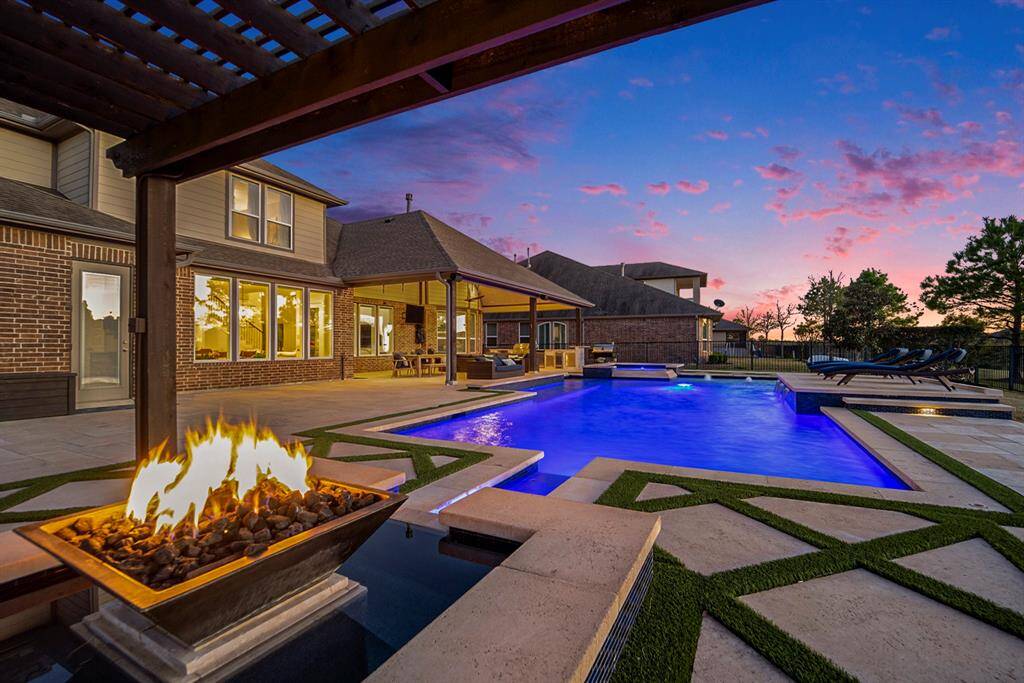 Backyard living space with fire & water features. Enjoy serene lake views from every angle of the backyard, enclosed by a rod-iron fence for privacy and tranquility.