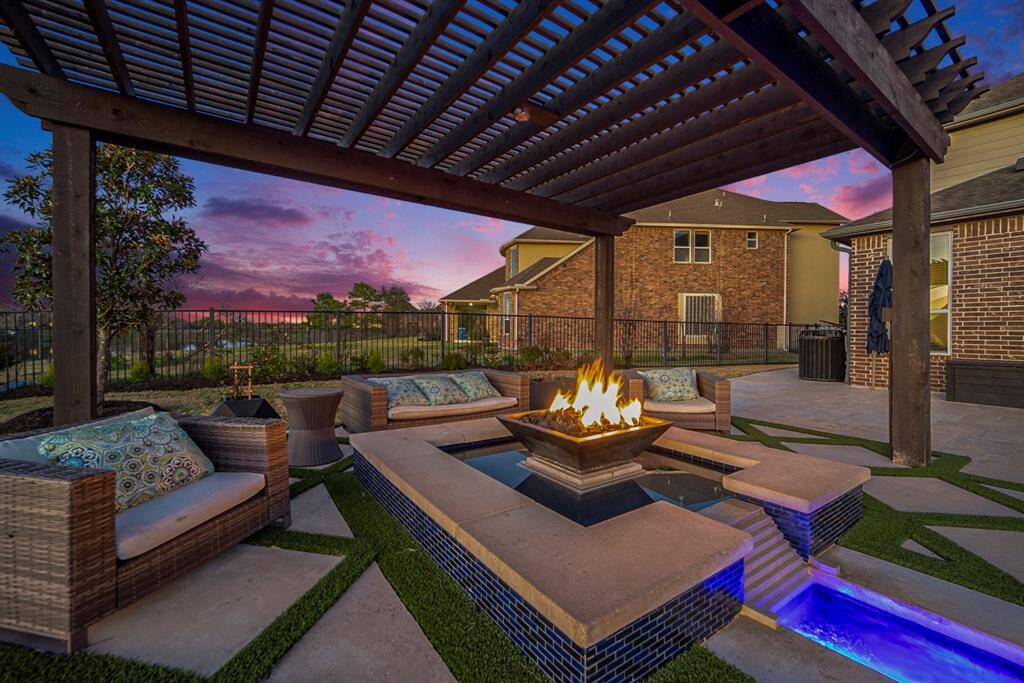 The backyard oasis includes a massive 14-foot hot tub with a waterfall, an oversized pool with a sun deck, a basketball goal, and a fire pit under a grand cabana.