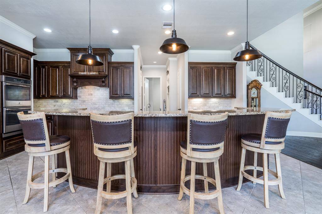 Charming bronze pendant lighting and traditional wainscotting adorn this fabulous island!
