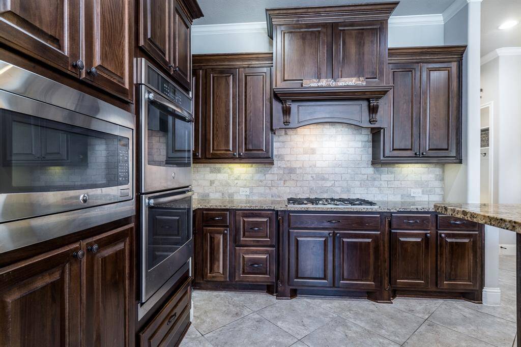 Granite countertops, travertine backsplash, stainless steel appliances, double ovens, and under cabinet lighting.... all waiting for the resident chef!
