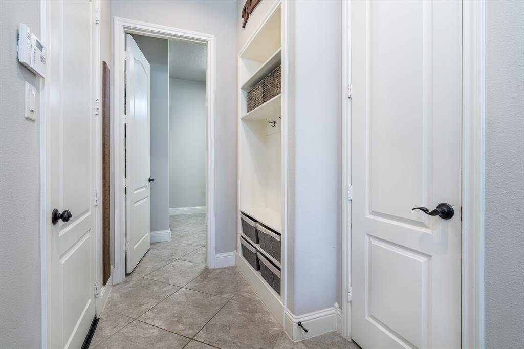 Adjacent to the utility room is a built-in storage area with hooks and shelving, offering the ideal solution to busy mornings! The door on the left leads to the 3 car garage and the door on the right leads to a huge walk-in pantry!