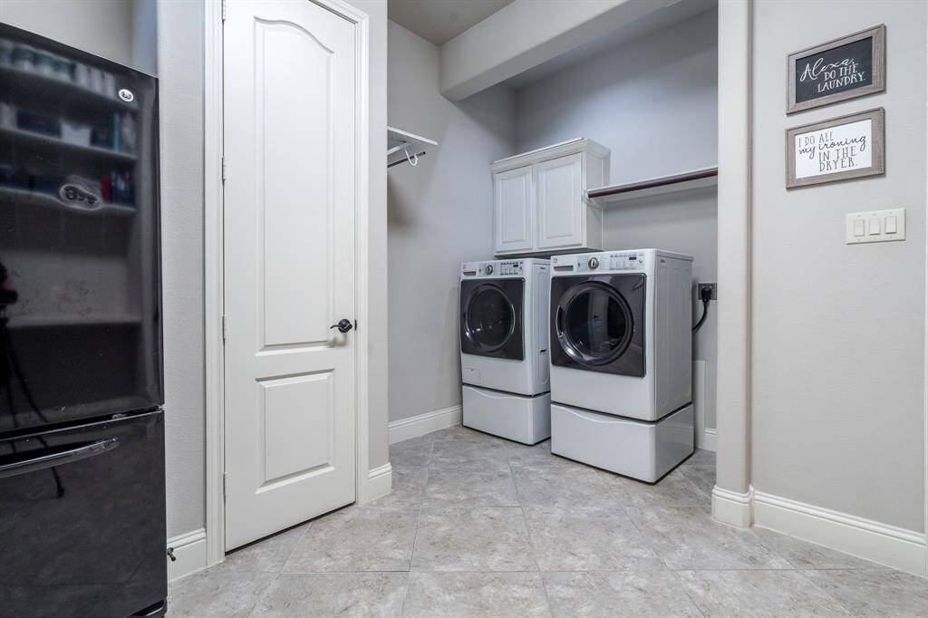 WOW! Look at this enormous utility room! There is a storage closet, space for additional appliances, built in shelving, cabinets and a hanging rack!