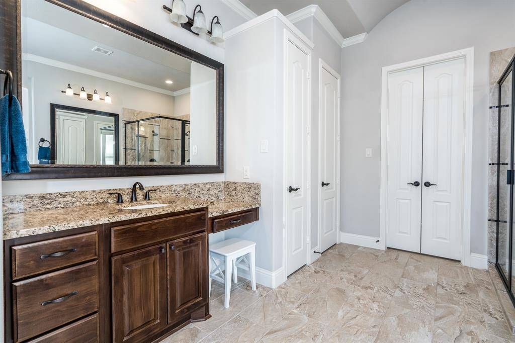Dual vanity sinks, one with knee space, provide abundant cabinets and drawers for storage plus granite countertops.