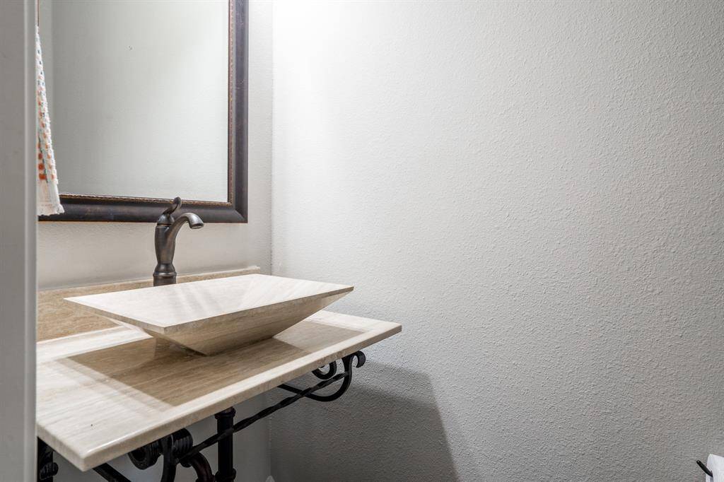 The powder room offers elegant, modern accents and is located off the main entry. It is just the right place for guests to freshen up!