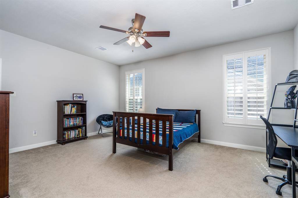 The second of four secondary bedrooms offers neutral paint and carpet, plantation shutters, ceiling fan and walk in closet! This bedroom has its own vanity and connects to a Jack n Jill bath.