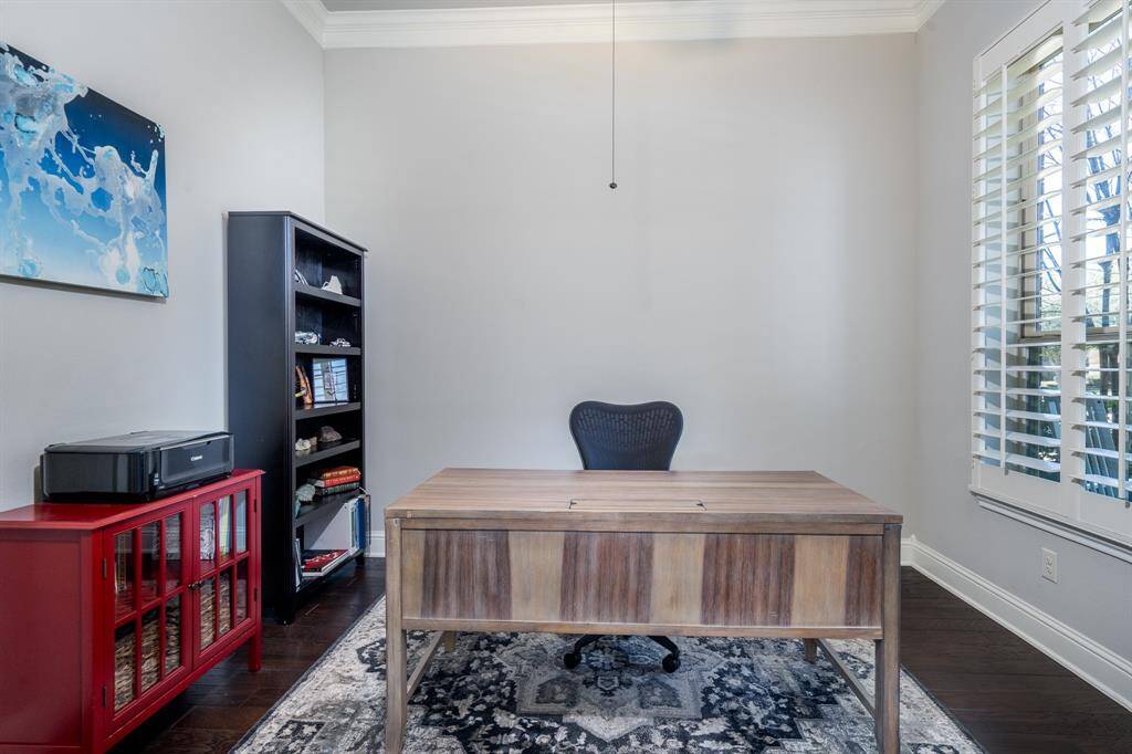 To the right of the entry is this private study with French doors, hardwood floors, tray ceiling, crown molding and plantation shutters.