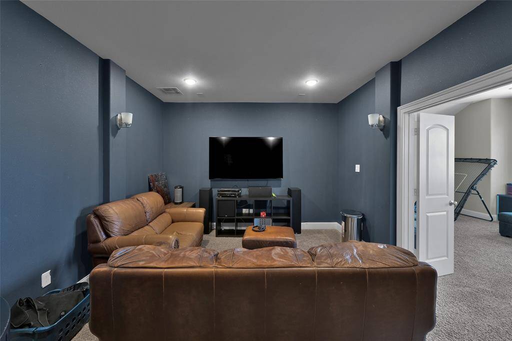 This cozy media room features dark blue walls, a mounted TV.