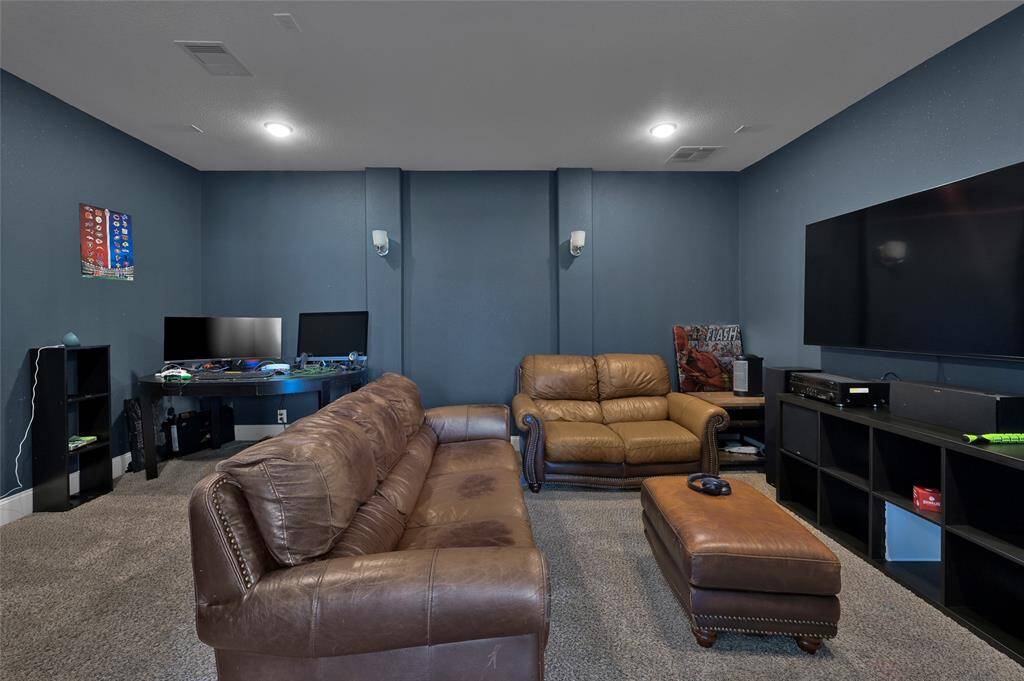 This space is perfect for entertainment and relaxation, with a dark blue color scheme and soft carpeting enhancing comfort.