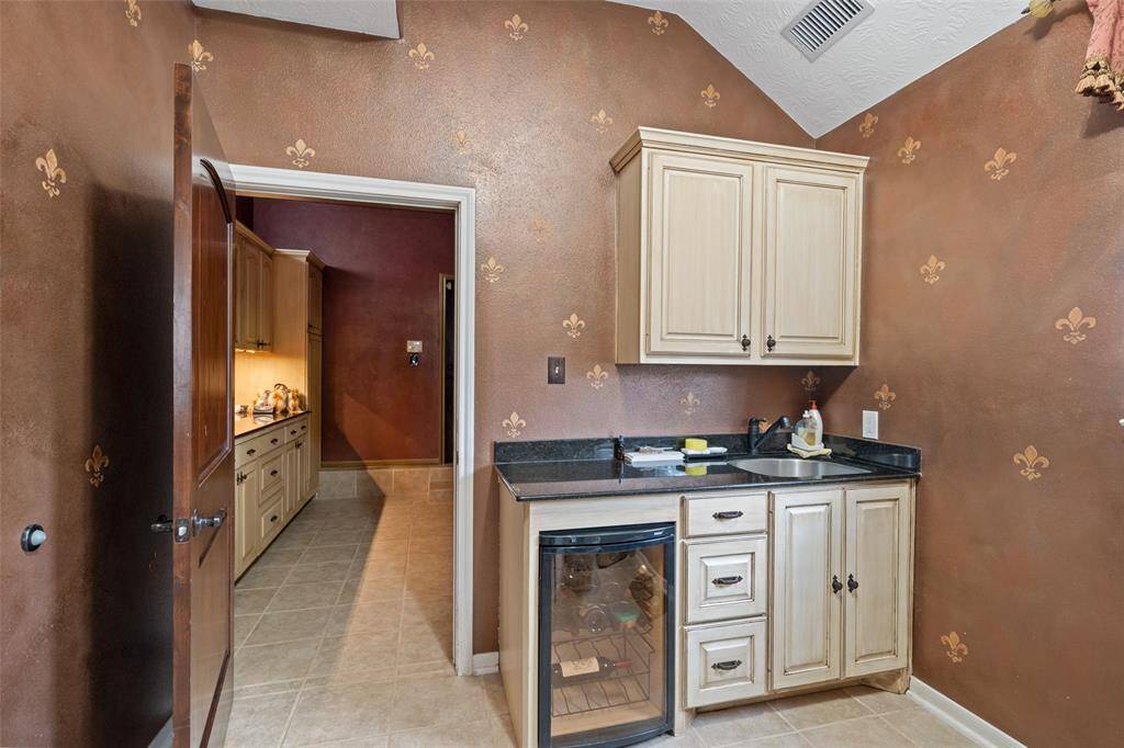FLEUR DE LIS WALLPAPER IN MUD ROOM WITH BUILT IN LIBATION FRIDGE