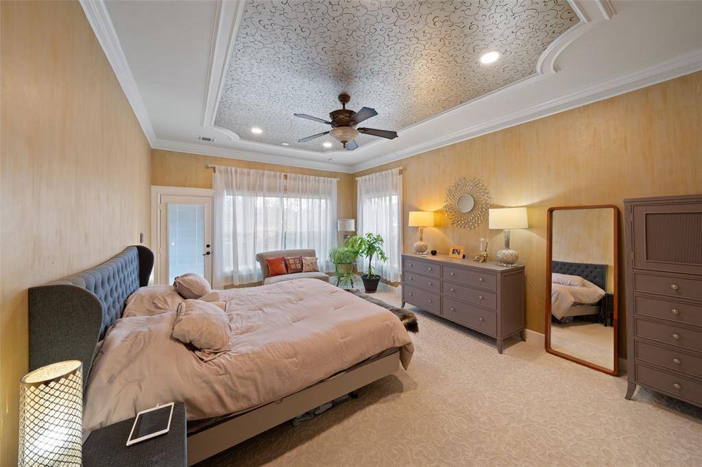 PRIMARY BEDROOM WITH VIEW TO THE LAKE AND MOTORIZED WINDOW SHADES OPERATED BY REMOTE
