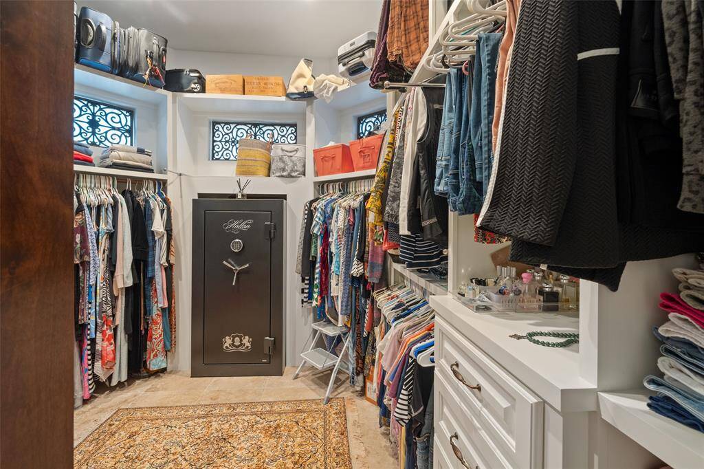 ROOMY PRIMARY CLOSET WITH CUSTOM SHELVING AND BUILT IN VALUABLE SAFE