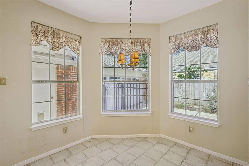 Enjoy breakfast with serene views of the pool, backyard, and lush green space.