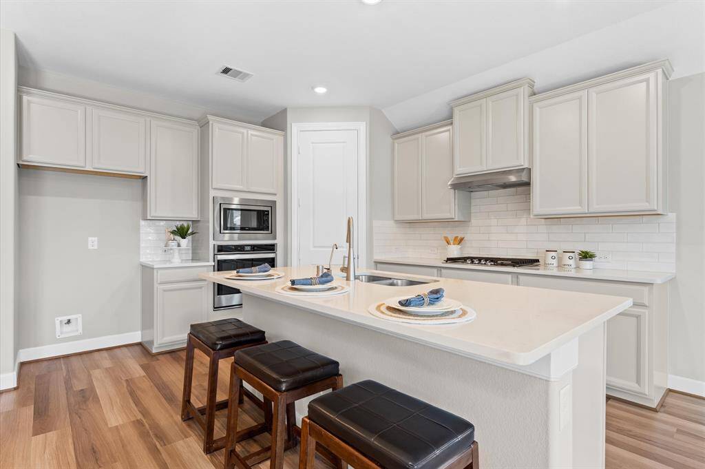 Sleek stainless steel appliances complement the custom cabinets, providing both beauty and efficiency.