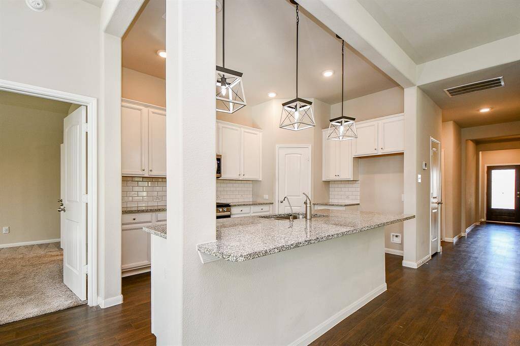 Modern kitchen with abundant cabinetry and expansive countertops.