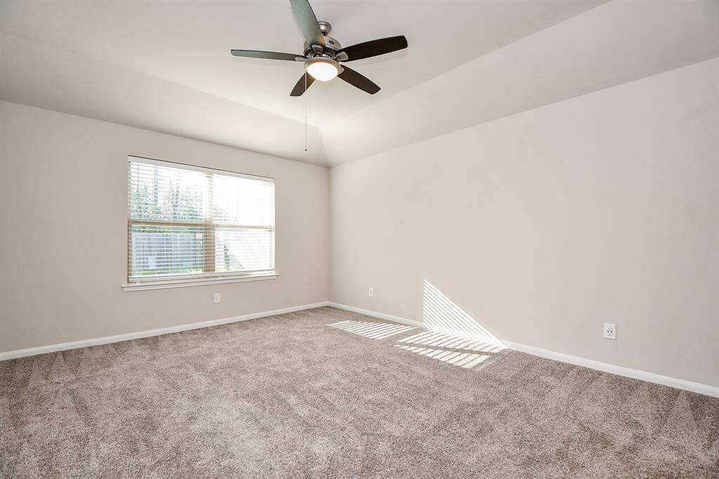 Bright and airy master bedroom with a ceiling fan for added comfort.