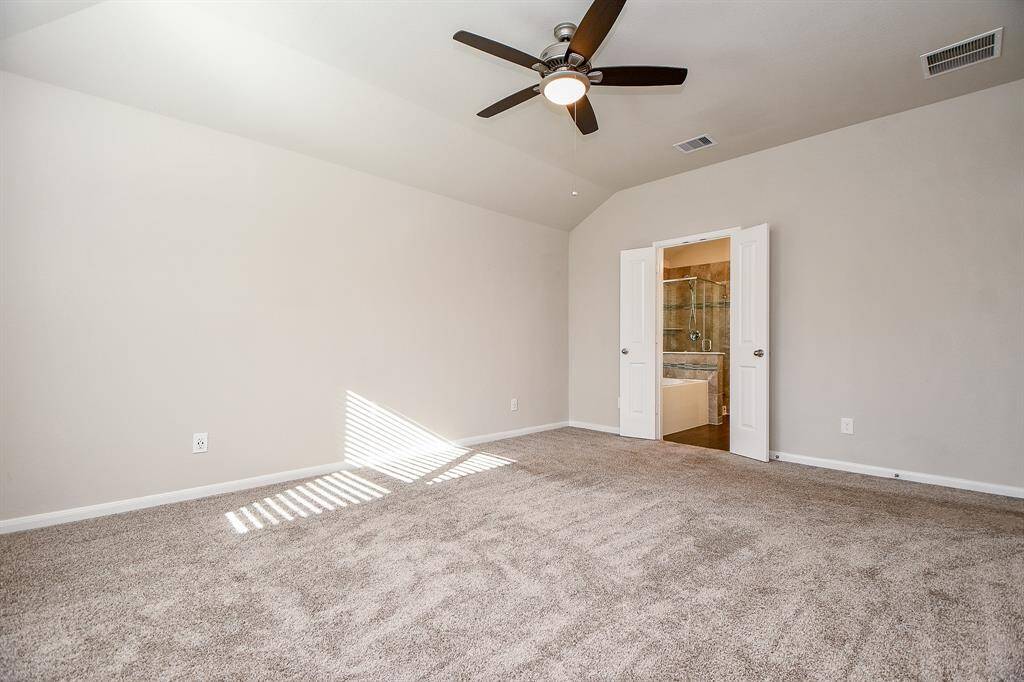Bright, spacious master bedroom with a ceiling fan for enhanced comfort.
